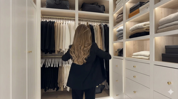 Woman browsing a walk-in wardrobe closet showing enclosed spaces where hanging moisture absorbers are most effective