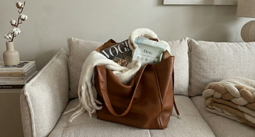 Leather bag and throw blanket on a couch in a humid Australian home, illustrating how mould can grow on clothes and fabric items